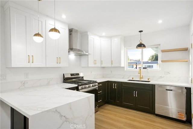 934 W Calora St, San Dimas, CA 91773 - kitchen featuring appliances with stainless steel finishes, wall chimney range hood, white cabinets, light stone counters, and light wood-style floors
