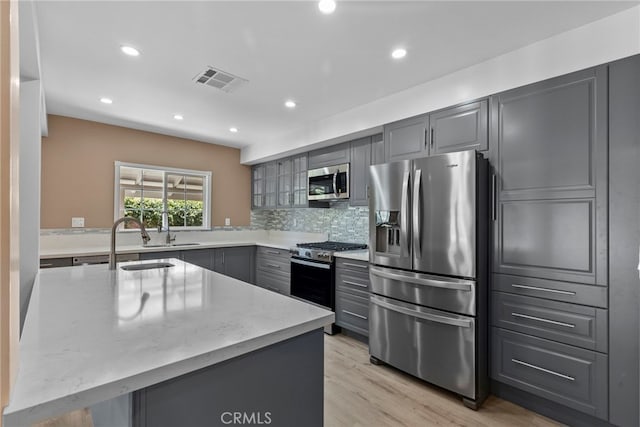 15711 Hiawatha St, Granada Hills, CA 91344 - kitchen with stainless steel appliances, gray cabinetry, light stone counters, decorative backsplash, and recessed lighting