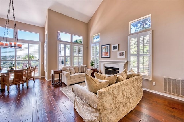 17 Siena, Laguna Niguel, CA 92677 - living room featuring dark wood finished floors, a towering ceiling, and a glass covered fireplace