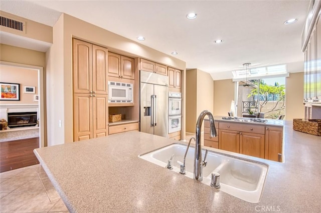 17 Siena, Laguna Niguel, CA 92677 - kitchen featuring built in appliances, recessed lighting, a peninsula, a glass covered fireplace, and light tile patterned floors
