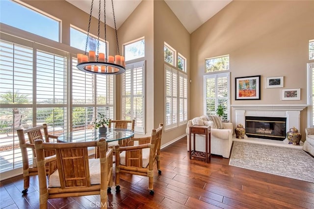 17 Siena, Laguna Niguel, CA 92677 - dining space with a high end fireplace, high vaulted ceiling, dark wood finished floors, and a chandelier