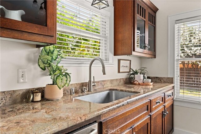 375 E 1st Ave, Chico, CA 95926 - kitchen featuring plenty of natural light, light stone counters, and glass insert cabinets