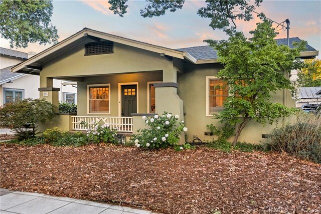 375 E 1st Ave, Chico, CA 95926 - view of front of house with covered porch, stucco siding, and roof with shingles