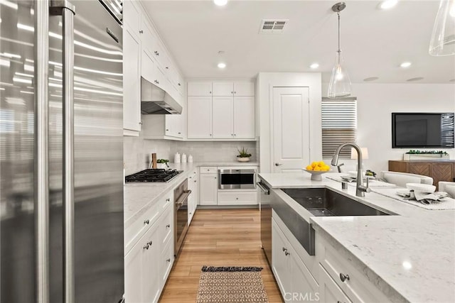 27636 S Evergreen Pl, San Pedro, CA 90732 - kitchen with stainless steel appliances, under cabinet range hood, white cabinets, backsplash, and recessed lighting