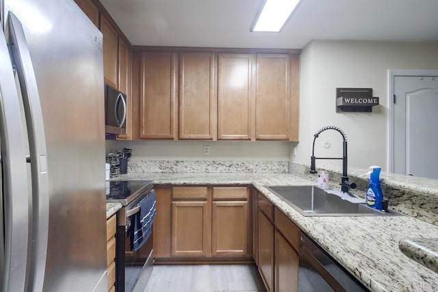 3454 Castle Glen Dr Unit 115, San Diego, CA 92123 - kitchen featuring appliances with stainless steel finishes, light wood-style floors, and light stone counters