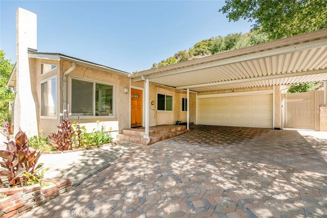 10919 Terecita Rd, Tujunga, CA 91042 - ranch-style house with stucco siding, an attached garage, driveway, and a chimney