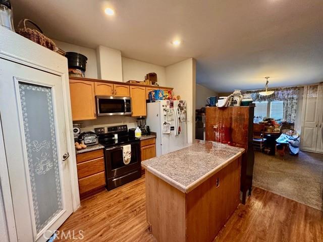 6475 105th St W, Rosamond, CA 93560 - kitchen with stainless steel appliances, light wood-style flooring, light countertops, brown cabinets, and recessed lighting