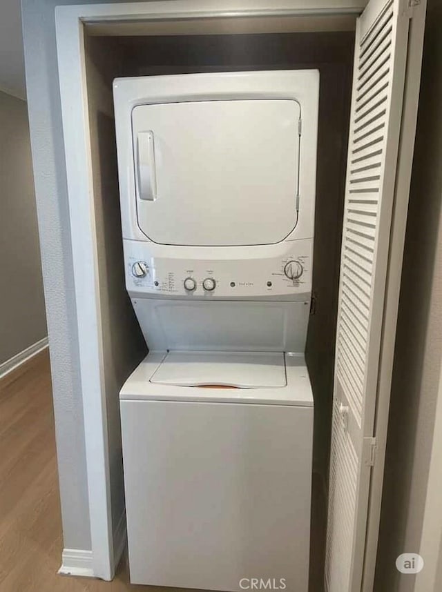 21520 Burbank Blvd Unit 116, Woodland Hills, CA 91367 - washroom featuring stacked washer / drying machine and wood finished floors