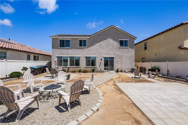5756 Quicksilver Way, Banning, CA 92220 - back of property with a fire pit, a patio area, solar panels, and a fenced backyard