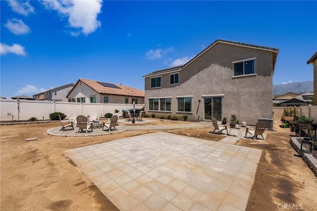 5756 Quicksilver Way, Banning, CA 92220 - back of property with an outdoor fire pit, a patio area, a fenced backyard, and stucco siding