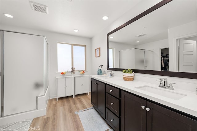 5756 Quicksilver Way, Banning, CA 92220 - bathroom featuring a stall shower, double vanity, wood finished floors, a walk in closet, and recessed lighting