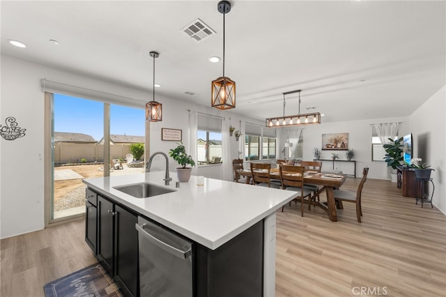 5756 Quicksilver Way, Banning, CA 92220 - kitchen with dishwasher, dark cabinetry, light wood-style floors, light countertops, and pendant lighting
