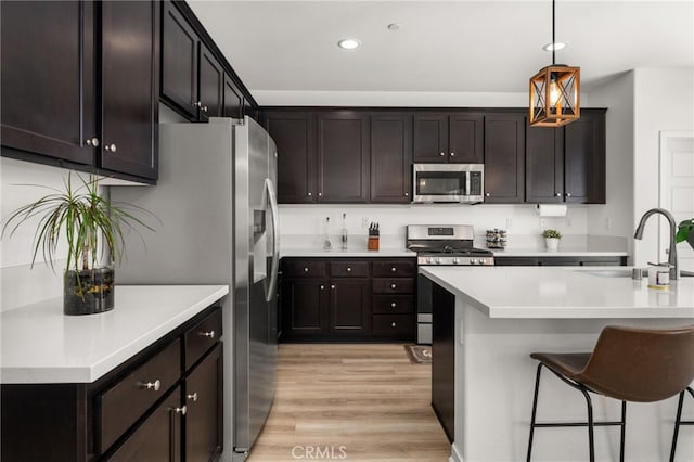 5756 Quicksilver Way, Banning, CA 92220 - kitchen with stainless steel appliances, light wood-style flooring, recessed lighting, light countertops, and hanging light fixtures