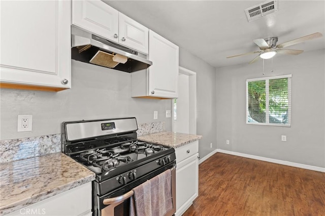 5609 Beach St, Jurupa Valley, CA 92509 - kitchen with gas stove, under cabinet range hood, dark wood-style floors, white cabinetry, and ceiling fan