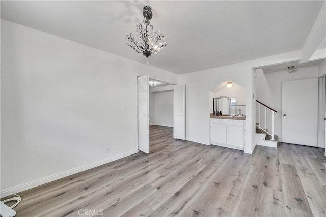 208 N Nicholson Ave Unit B, Monterey Park, CA 91755 - unfurnished living room with light wood-style flooring, stairs, a chandelier, and arched walkways
