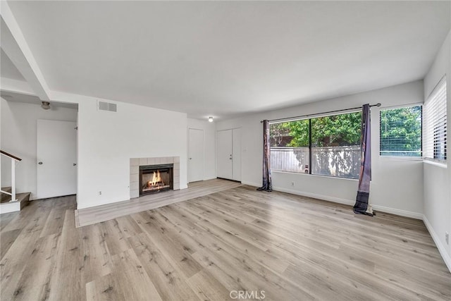 208 N Nicholson Ave Unit B, Monterey Park, CA 91755 - unfurnished living room with stairs, light wood-style flooring, and a tiled fireplace