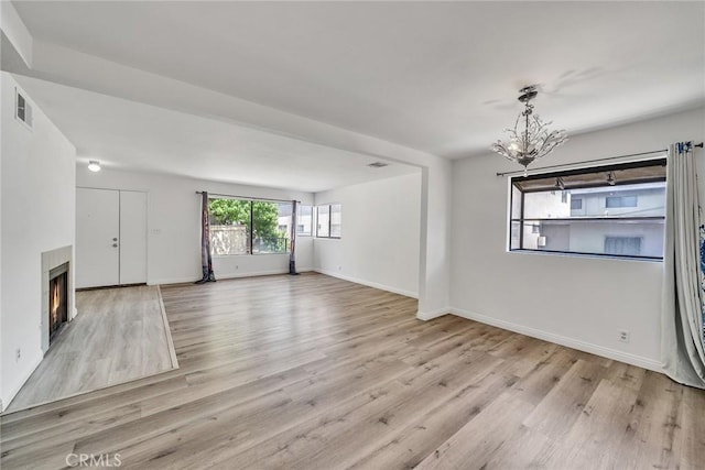 208 N Nicholson Ave Unit B, Monterey Park, CA 91755 - unfurnished living room featuring a chandelier, wood finished floors, and a lit fireplace