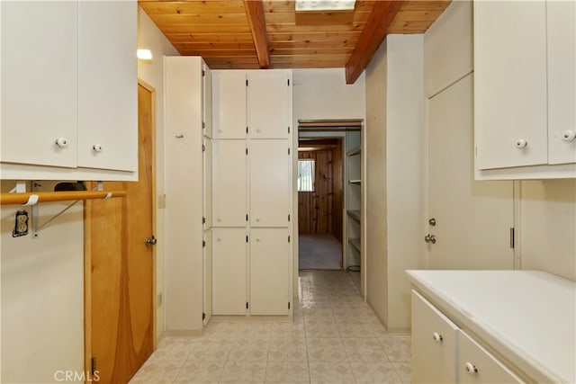 33469 Squirrel Dr, Green Valley Lake, CA 92341 - kitchen featuring a wooden ceiling with exposed beams, white cabinets, light tile patterned floors, and light countertops