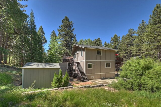 33469 Squirrel Dr, Green Valley Lake, CA 92341 - rear view of house with stairway, a storage shed, a wooden deck, crawl space, and board and batten siding