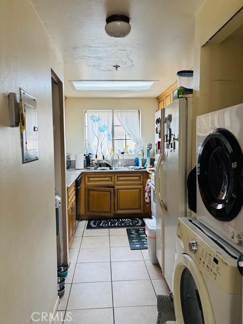 215 S 5th St, Alhambra, CA 91801 - laundry area with stacked washing machine and dryer and light tile patterned flooring