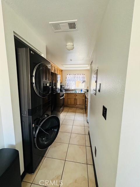 215 S 5th St, Alhambra, CA 91801 - laundry area with estacked washer and dryer and light tile patterned floors