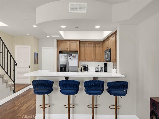 5753 White Oak Ave Unit 3, Encino, CA 91316 - kitchen with appliances with stainless steel finishes, a peninsula, brown cabinets, recessed lighting, and tasteful backsplash