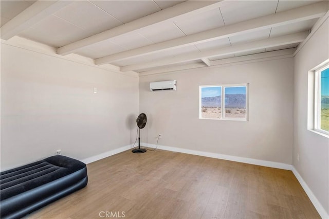 81122 Valle Vista Rd Unit 29, Palms, CA 92277 - unfurnished room with a wall mounted AC, wood finished floors, and beam ceiling