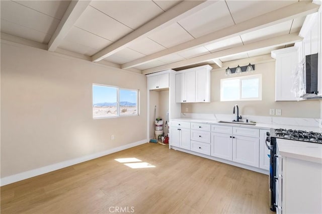 81122 Valle Vista Rd Unit 29, Palms, CA 92277 - kitchen with gas range, beam ceiling, light wood finished floors, healthy amount of natural light, and light countertops