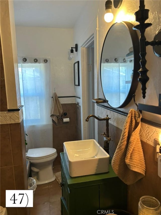 1388 N Lugo Ave, San Bernardino, CA 92404 - bathroom featuring tile walls, tile patterned floors, vanity, and wainscoting