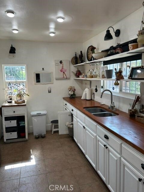 1388 N Lugo Ave, San Bernardino, CA 92404 - kitchen featuring wood counters, white cabinets, and light tile patterned flooring