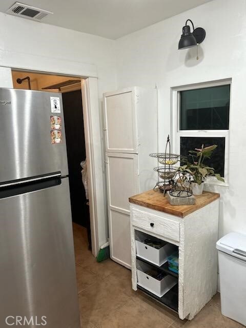 1388 N Lugo Ave, San Bernardino, CA 92404 - kitchen featuring freestanding refrigerator, light tile patterned flooring, and light countertops