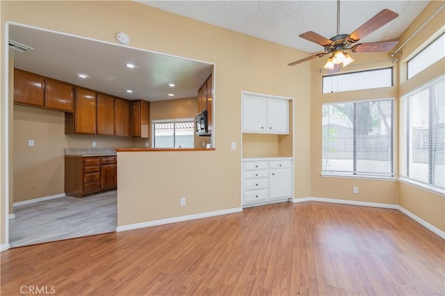 45 Willowcrest Ln, Pomona, CA 91766 - kitchen with black microwave, brown cabinetry, light wood finished floors, and ceiling fan