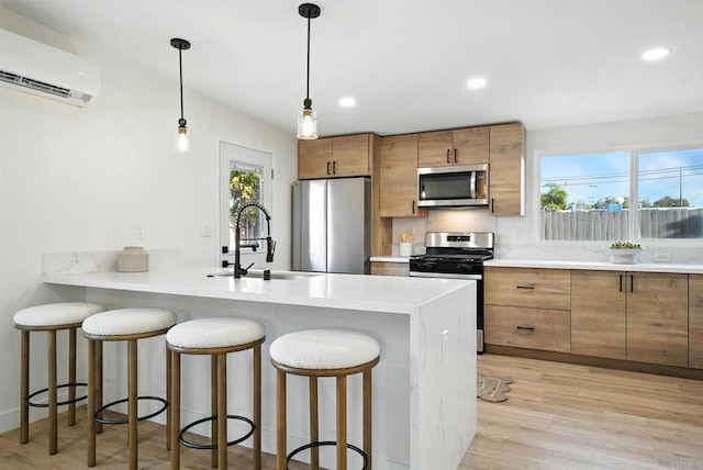 1143 Hemlock Ave, Imperial Beach, CA 91932 - kitchen with appliances with stainless steel finishes, a wall mounted air conditioner, brown cabinets, a breakfast bar, and recessed lighting