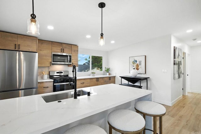 1143 Hemlock Ave, Imperial Beach, CA 91932 - kitchen with stainless steel appliances, brown cabinets, light wood-style flooring, decorative light fixtures, and recessed lighting