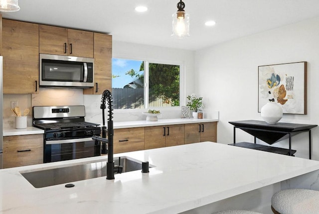 1143 Hemlock Ave, Imperial Beach, CA 91932 - kitchen with appliances with stainless steel finishes, brown cabinets, pendant lighting, recessed lighting, and decorative backsplash