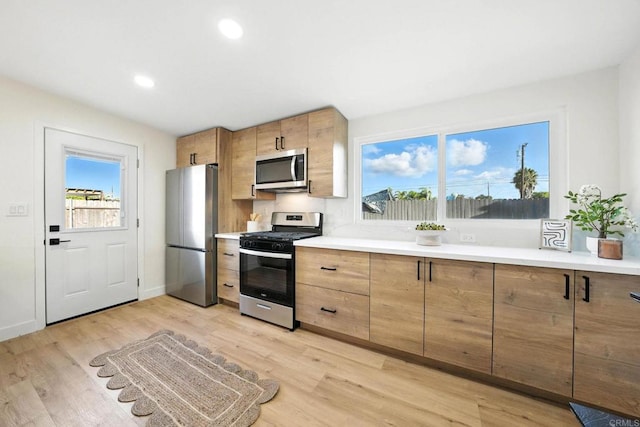 1143 Hemlock Ave, Imperial Beach, CA 91932 - kitchen featuring appliances with stainless steel finishes, light wood finished floors, plenty of natural light, light countertops, and recessed lighting