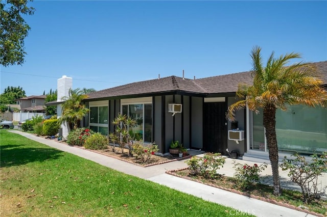 13282 Verde St, Garden Grove, CA 92844 - view of front of property featuring a front lawn, a chimney, cooling unit, and board and batten siding