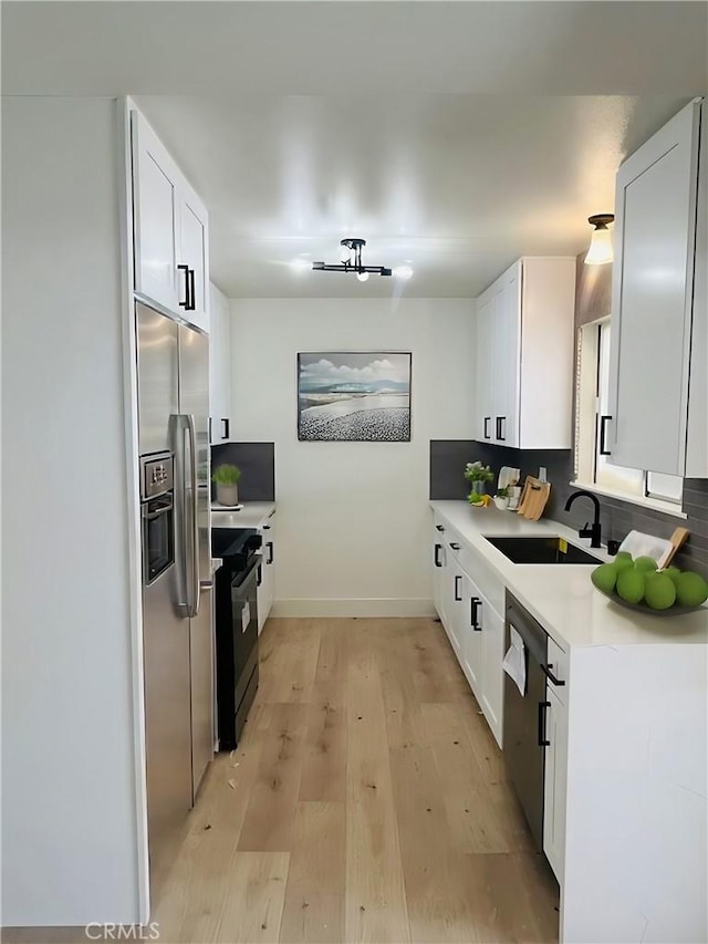 13282 Verde St, Garden Grove, CA 92844 - kitchen with stainless steel appliances, white cabinetry, light countertops, and light wood finished floors