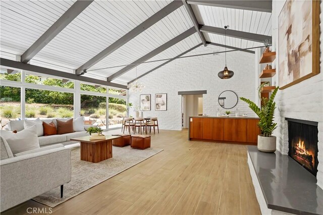 1987 Windover Rd, Pasadena, CA 91107 - living area featuring high vaulted ceiling, light wood-style floors, beamed ceiling, a lit fireplace, and brick wall
