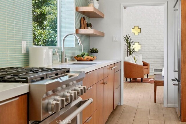 1987 Windover Rd, Pasadena, CA 91107 - kitchen with decorative backsplash, light countertops, stainless steel range with gas cooktop, and open shelves