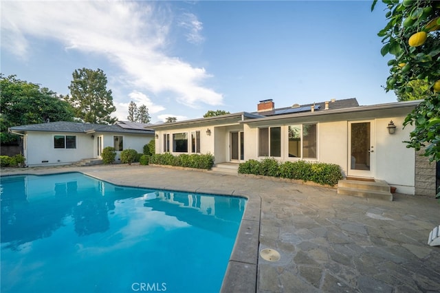 1525 Lafayette Rd, Claremont, CA 91711 - back of property featuring entry steps, solar panels, a chimney, and an outdoor pool