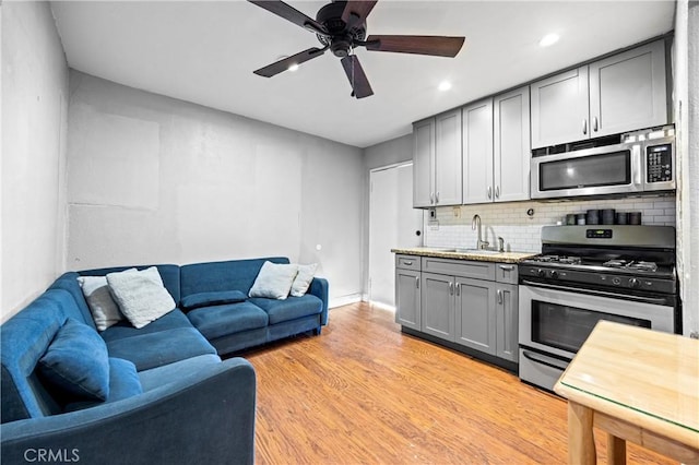 6362 Darlington Ave, Buena Park, CA 90621 - kitchen featuring stainless steel appliances, gray cabinetry, tasteful backsplash, a ceiling fan, and open floor plan