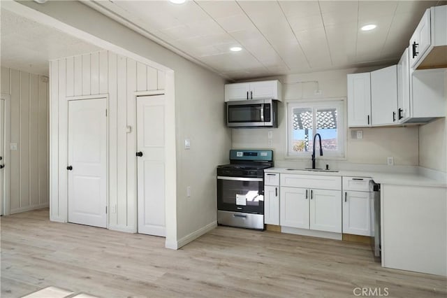 7888 Victor, Yucca Valley, CA 92284 - kitchen with appliances with stainless steel finishes, light countertops, white cabinetry, recessed lighting, and light wood-type flooring