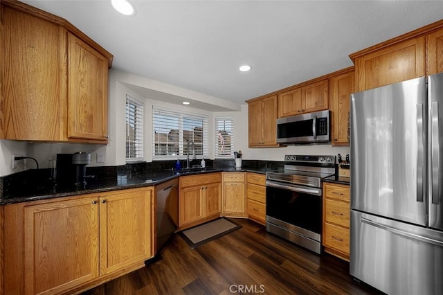 4773 Adler, Oceanside, CA 92057 - kitchen with appliances with stainless steel finishes, dark wood-style flooring, recessed lighting, dark stone counters, and brown cabinetry