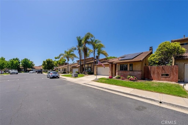4773 Adler, Oceanside, CA 92057 - view of front of house featuring solar panels, a chimney, a residential view, and a garage