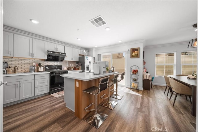 9804 Ardisia St, Riverside, CA 92503 - kitchen with gas stove, stainless steel refrigerator with ice dispenser, ornamental molding, tasteful backsplash, and gray cabinetry