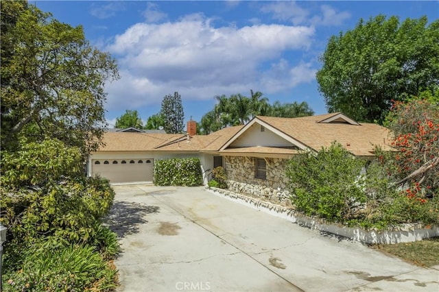 1725 Turnbull Canyon Rd, Hacienda Heights, CA 91745 - ranch-style home with an attached garage, concrete driveway, stone siding, and a chimney