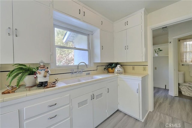 330 N Madison Ave, Monrovia, CA 91016 - kitchen featuring backsplash, tile counters, and white cabinets