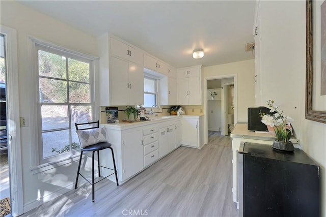 330 N Madison Ave, Monrovia, CA 91016 - kitchen with white cabinets, light countertops, light wood-style flooring, and decorative backsplash
