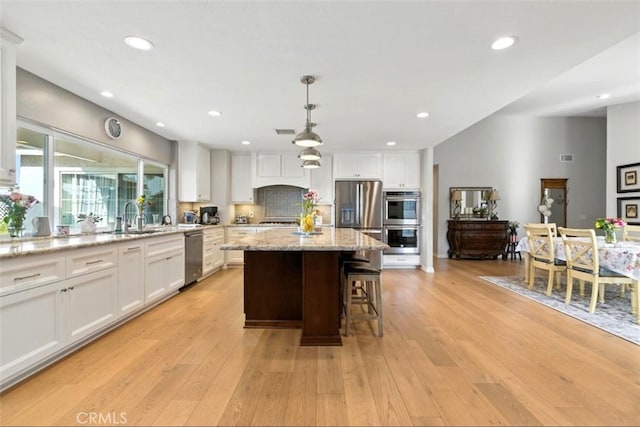 3526 Alder Pl, Chino Hills, CA 91709 - kitchen with stainless steel appliances, a center island, white cabinetry, light wood-type flooring, and recessed lighting